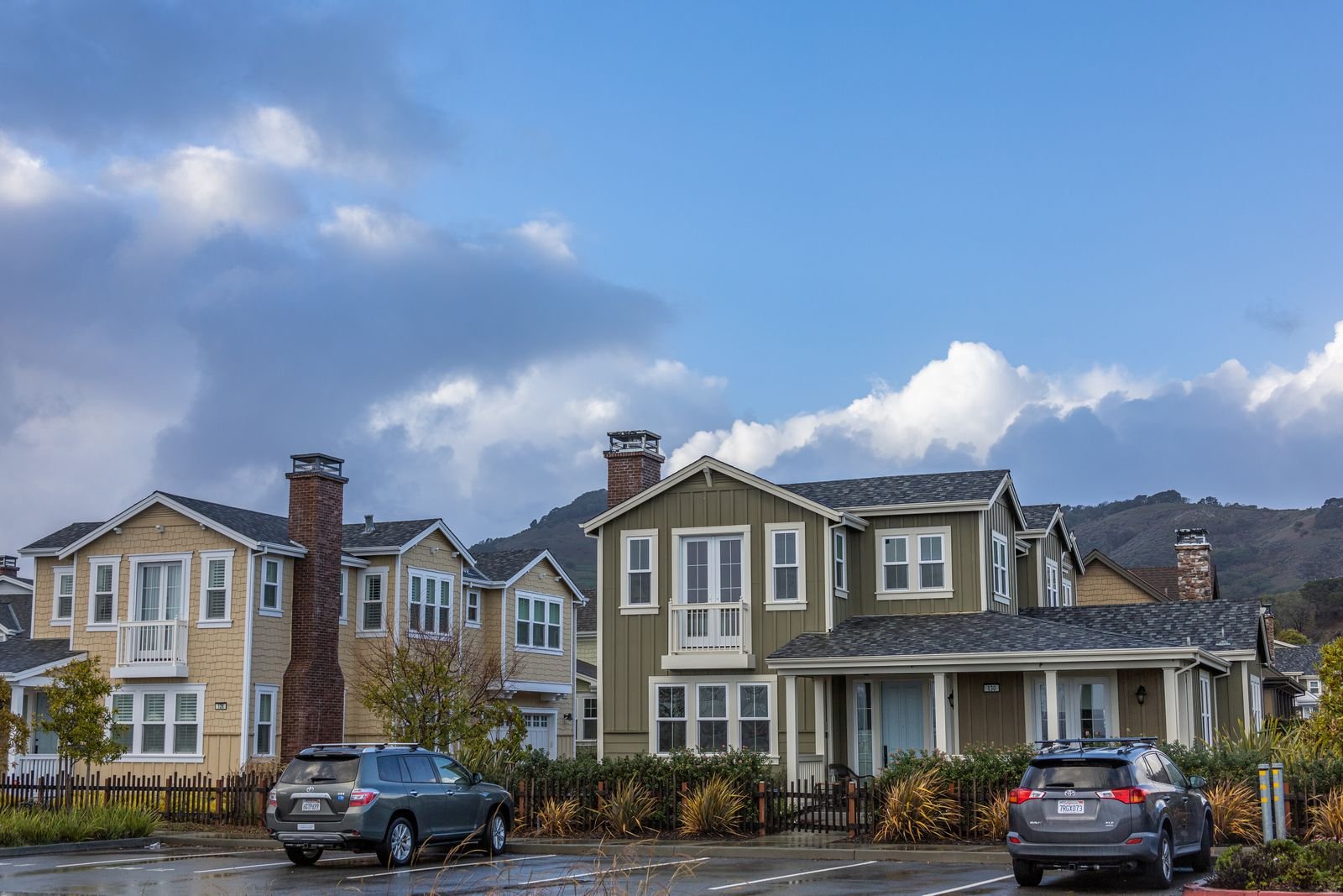 Row of detached family homes on a residential street under a blue sky